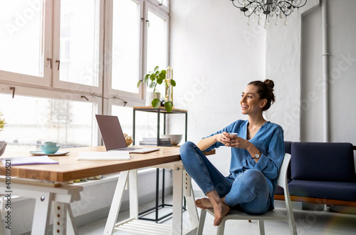 Portrait of a smiling creative woman in a modern loft space
