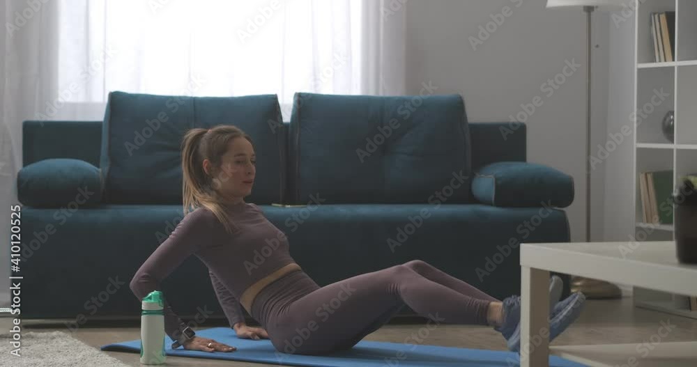 young woman with ponytail is doing crunches on floor at home, sporty training and fitness workout, healthy lifestyle young woman with ponytail is doing crunches on floor at home, sporty training and fitness workout, healthy lifestyle