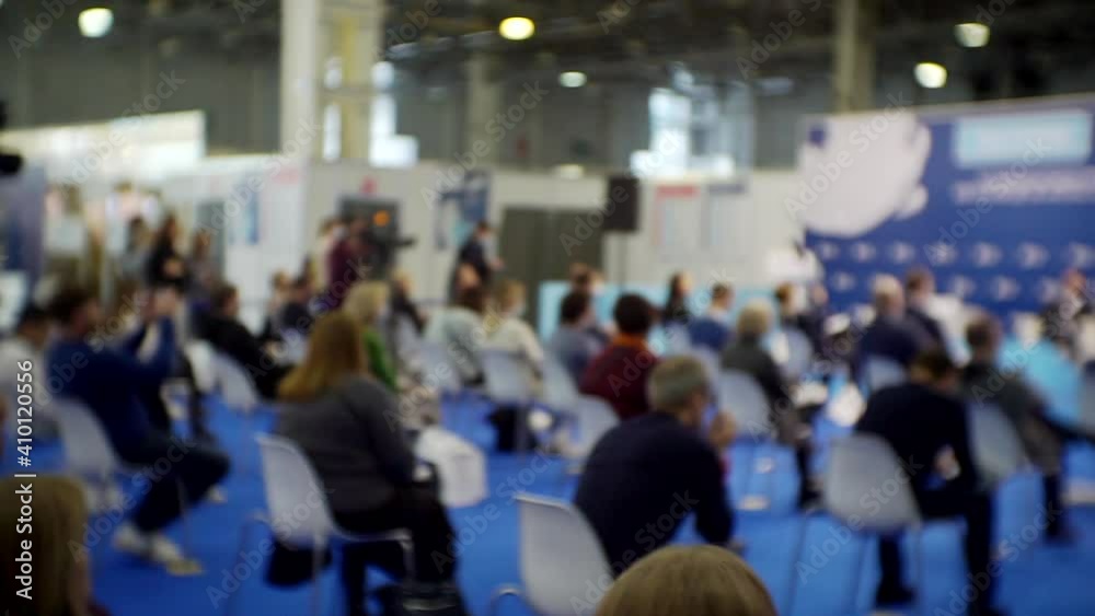 blurred background. People in the large hall at a business presentation blurred background. People in the large hall at a business presentation