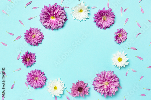 Frame made of colorful flowers on pastel blue background