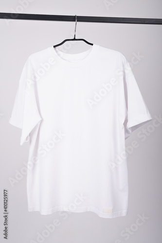 White T-shirt hangs on a hanger