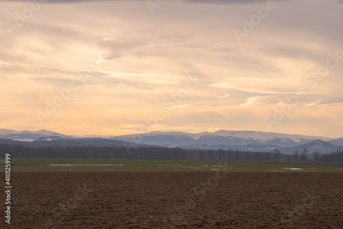 Widok na odległe Karkonosze z wieczornym niebem w tle.