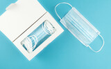 directly above view of medical face masks in dispenser box on blue background