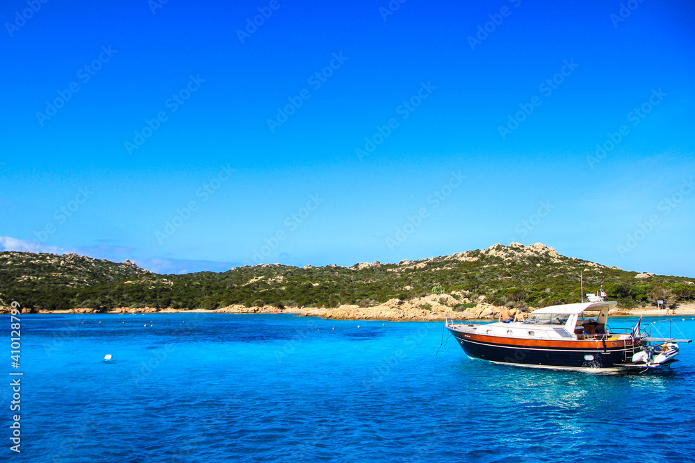 photo of a boat anchored in the mediterranean sea near a beach	