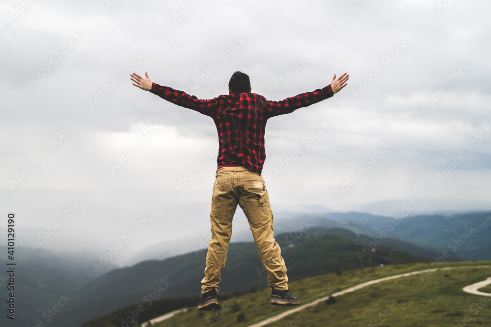 Carefree jump in mountain peak Carefree jump in mountain peak
