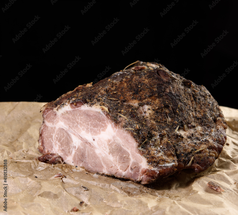baked piece of spiced pork neck on brown parchment paper