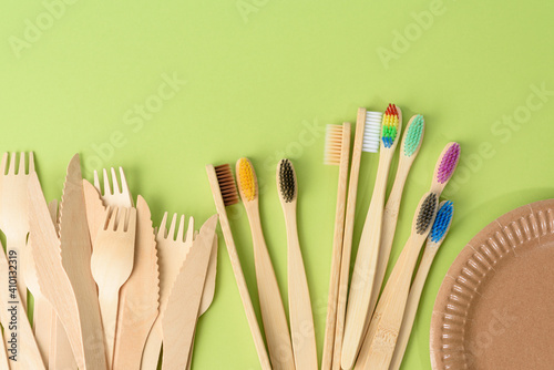 toothbrushes and wooden fork and empty round brown disposable plate made from recycled materials