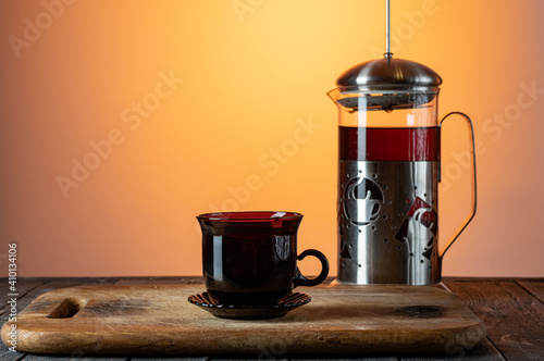 Glass flask with tea. Tea mug and teapot. Tea on the kitchen board. photo