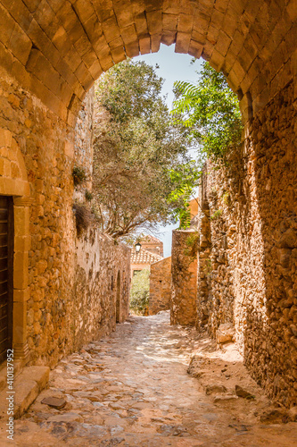narrow alley with cobblestones and stone walls in medieval Monemvasia  Peleponnese  Greece