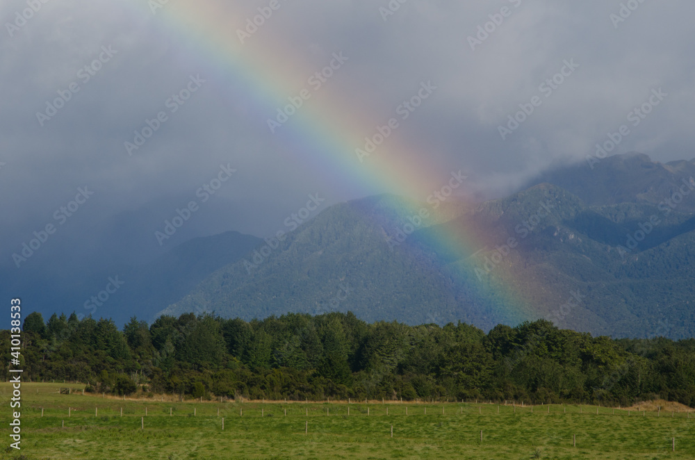 Rainbow in Southland. Southland and Fiorland National Park in the background. South Island. New Zealand. Rainbow in Southland. Southland and Fiorland National Park in the background. South Island. New Zealand.