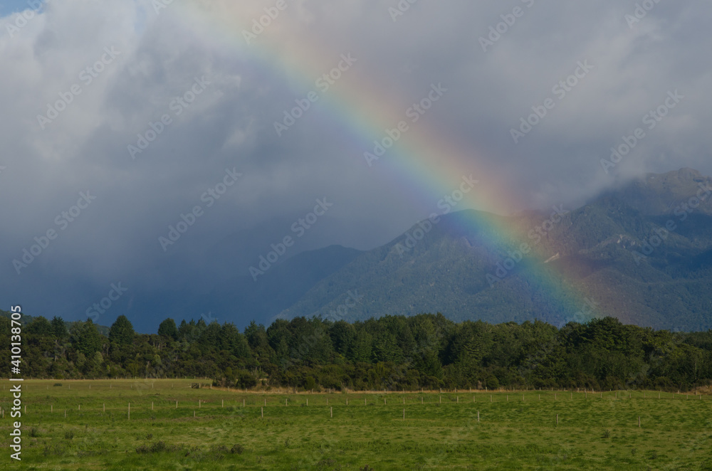 Rainbow in Southland. Southland and Fiorland National Park in the background. South Island. New Zealand. Rainbow in Southland. Southland and Fiorland National Park in the background. South Island. New Zealand.