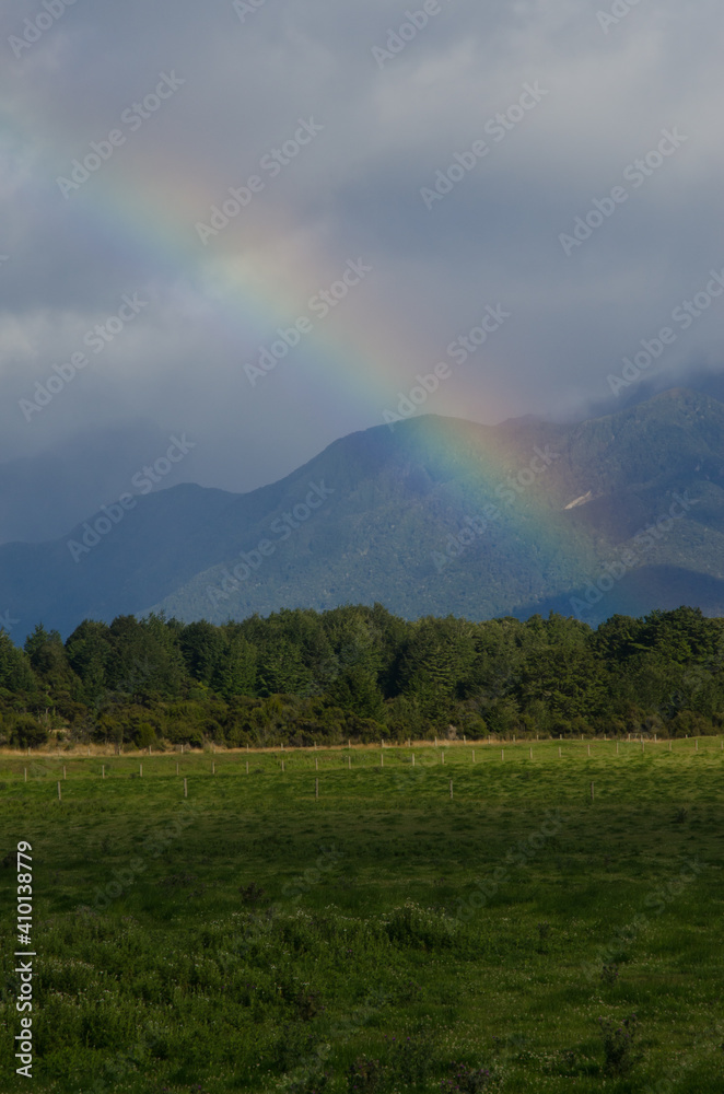 Rainbow in Southland. Southland and Fiorland National Park in the background. South Island. New Zealand.