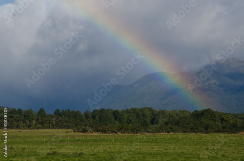 Rainbow in Southland. Southland and Fiorland National Park in the background. South Island. New Zealand.