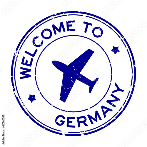 Grunge blue welcome to Germany word with airplane icon round rubber seal stamp on white background