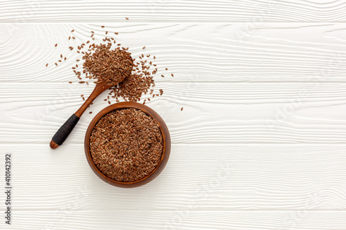 Flax seeds in a spoon and bowl with a bottle of flaxseed oil