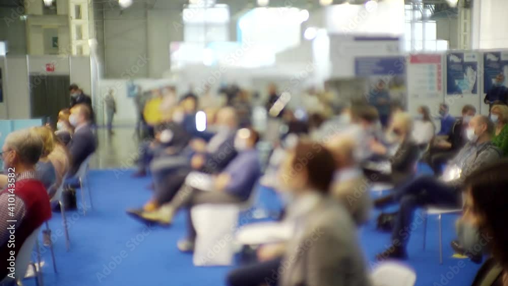 blurred background. People in the large hall at a business presentation