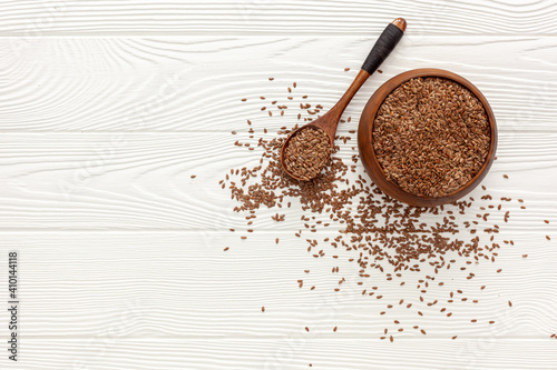 Flax seeds in a spoon and bowl with a bottle of flaxseed oil