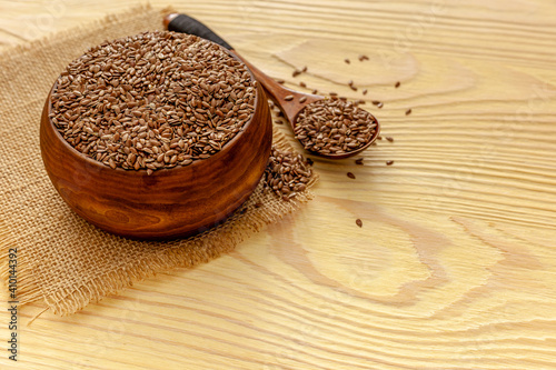 Flax seeds in a spoon and bowl with a bottle of flaxseed oil