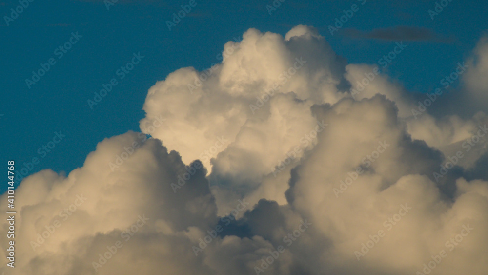 Gros cumulus amoncelés, formant un véritable mur nuageux aux couleurs chaleureuses Gros cumulus amoncelés, formant un véritable mur nuageux aux couleurs chaleureuses