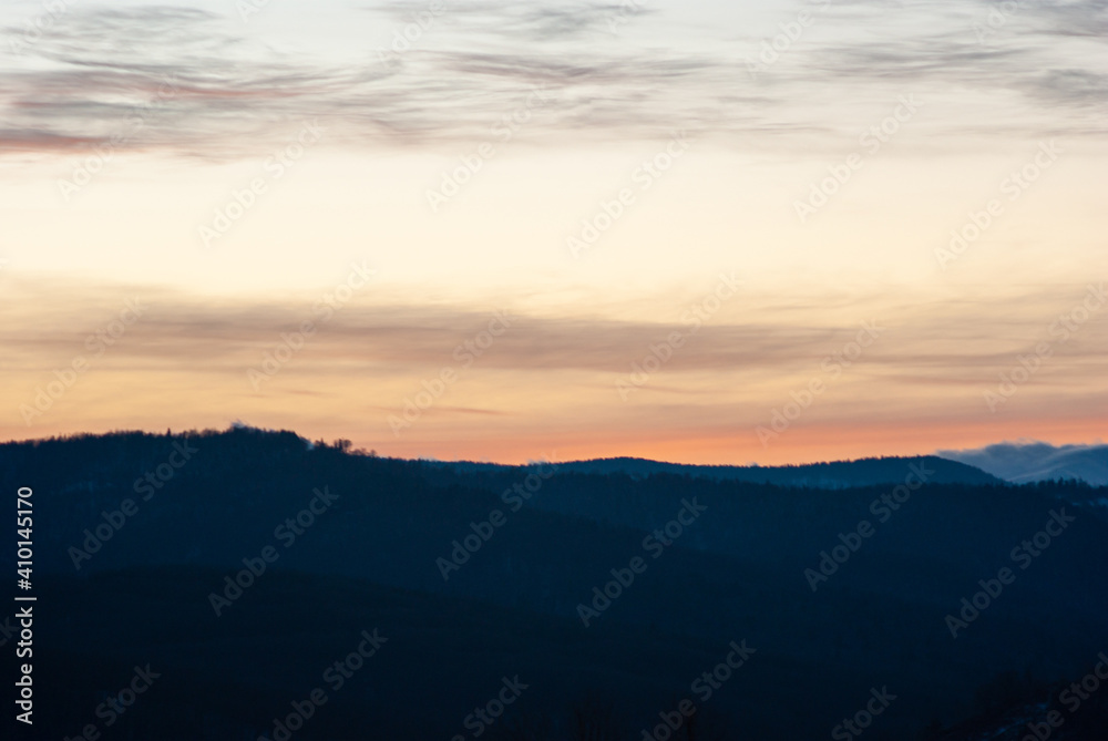 Silhouette of hills and forest at sunset