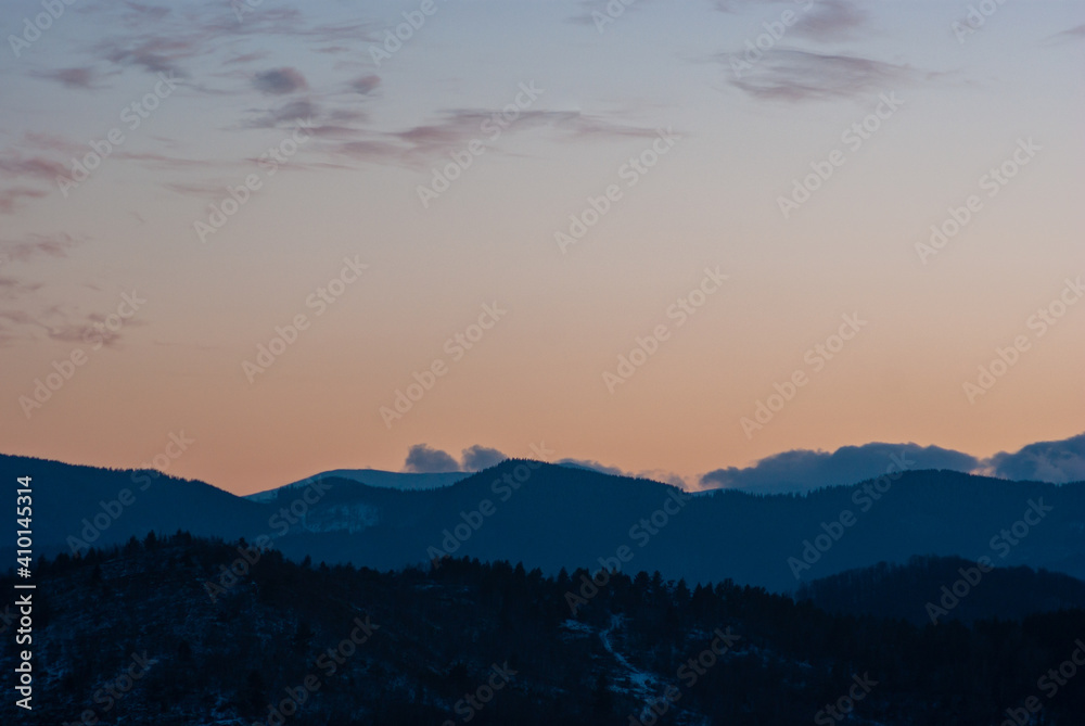 Obraz premium Silhouette of hills and forest at sunset
