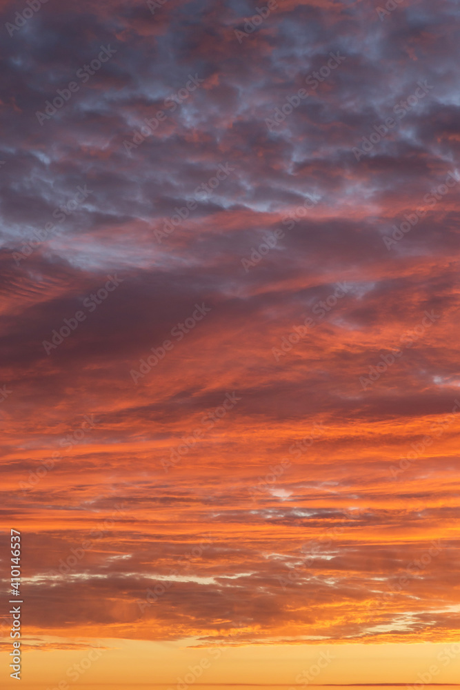 Epic Dramatic sunrise, sunset orange red yellow pink clouds against blue sky background texture