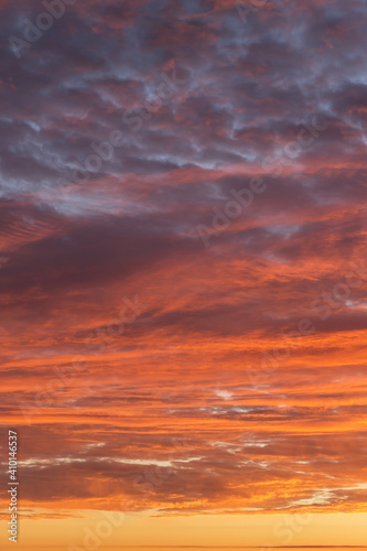 Epic Dramatic sunrise, sunset orange red yellow pink clouds against blue sky background texture © Viktor Iden