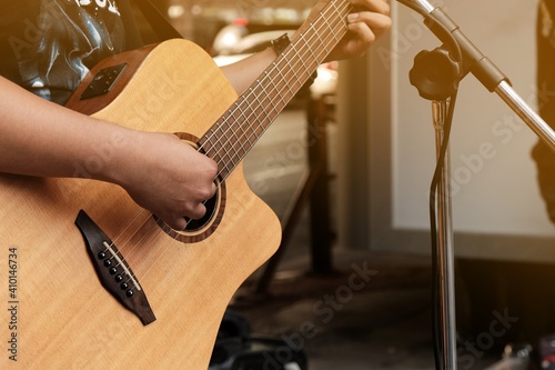 An artist playing acoustic guitar on the street