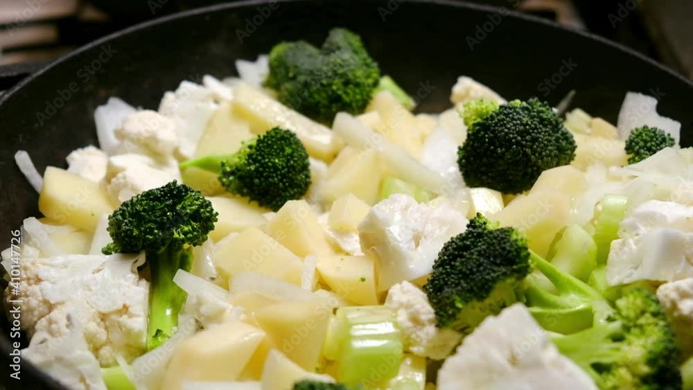 Cooking vegetable stew. Various vegetables are stewed - potatoes, onions, broccoli, cauliflower in a pan. Cooking vegetable stew. Various vegetables are stewed - potatoes, onions, broccoli, cauliflower in a pan.