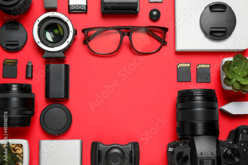 Flat lay composition with camera and video production equipment on red background. Space for text
