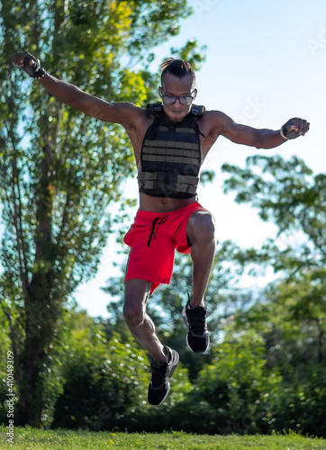 Colored athlete performs a jump with a vest
