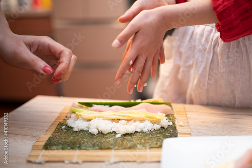 巻き寿司を作る親子の手元