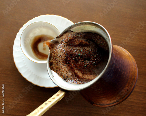 Pouring coffee into cup , from the copper pot cezve, Turkish coffee, top view