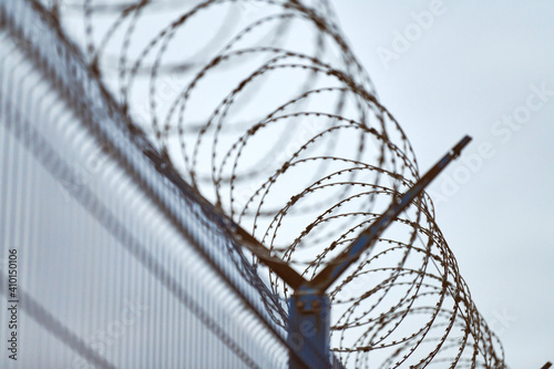 Barbed wire on fence of restricted area photo