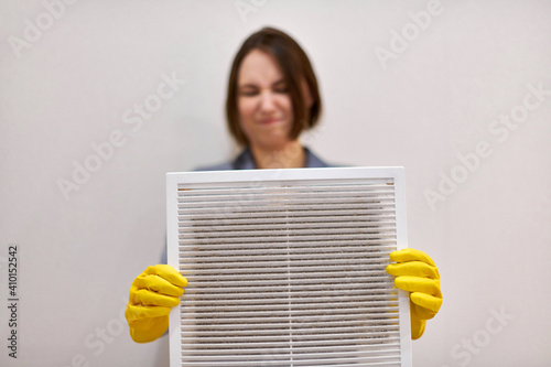 Obraz na płótnie Woman holding dirty and dusty ventilation grille, disgusted