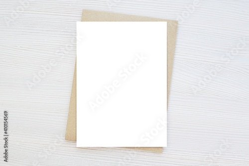 Blank vertical card mockup, invitation, greeting card mock up, brown envelope, wooden background, minimal style.