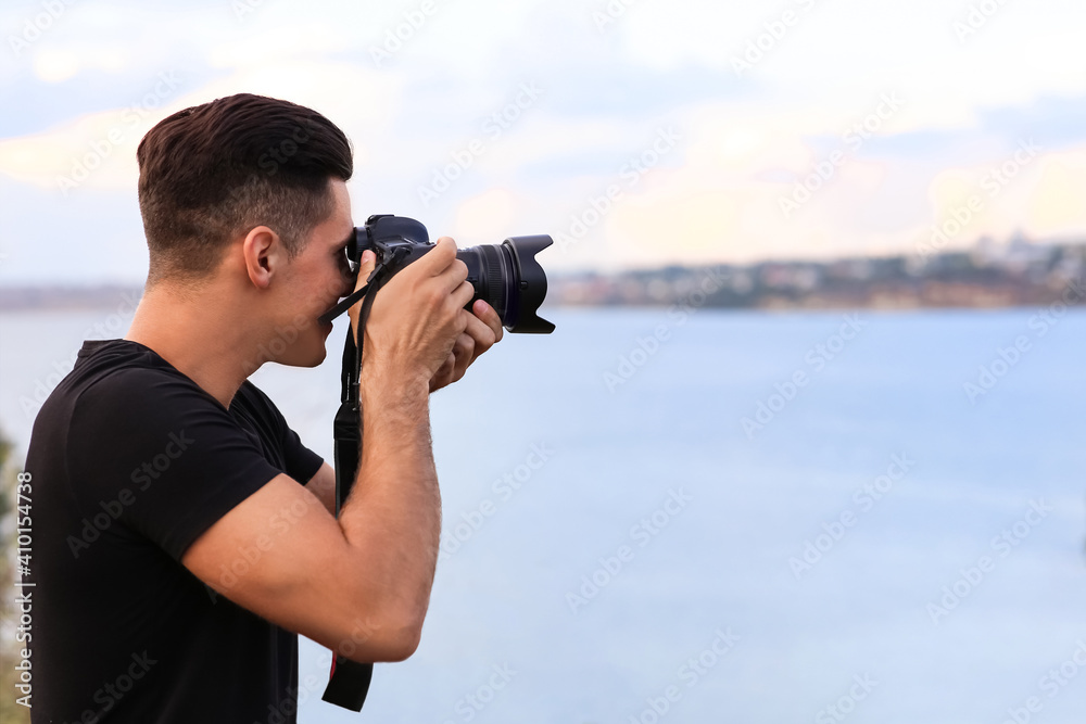 Photographer taking picture with professional camera near river Photographer taking picture with professional camera near river