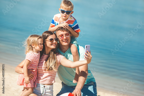 Happy family on the beach. Family vacation. People making selfie on cell phone