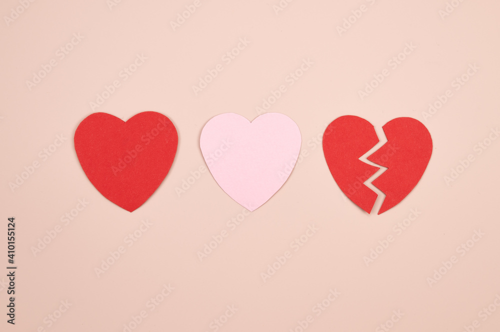 Paper hearts over the pink pastel background. Abstract background with paper cut shapes. Broken heart love relationship concept