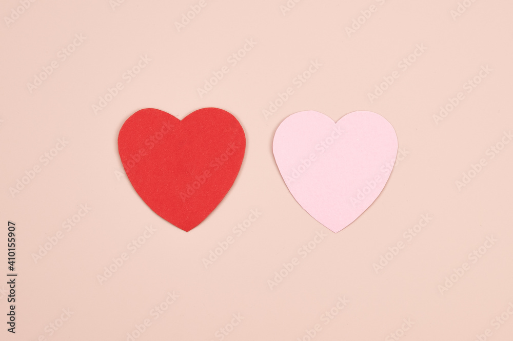 Two paper hearts on pink background. Symbol of love relationship. Pastel pink background with copy space.