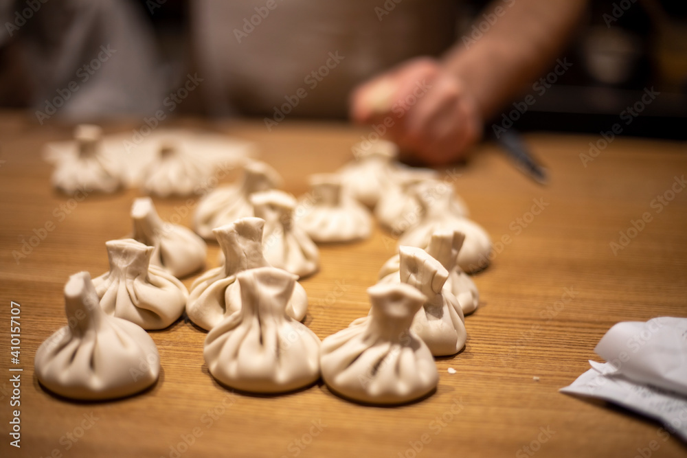 cook raw khinkali on a wooden table, horizontal cook raw khinkali on a wooden table, horizontal