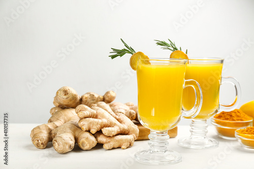 Immunity boosting drink and ingredients on white wooden table. Space for text