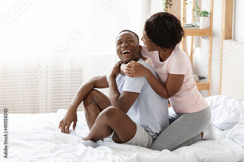 Young african american lovers bonding in bed and laughing