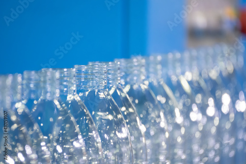 The PET bottles on the conveyor belt for filling process in the drinking water factory. The hi-technology of plastic bottle manufacturing process.