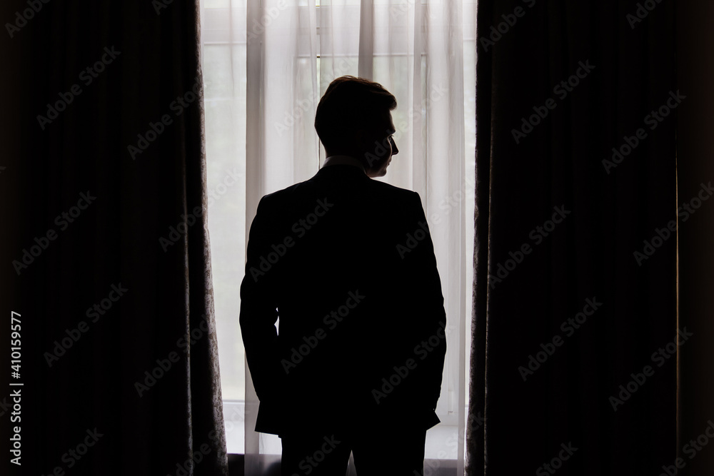 silhouette. man in jacket near the window. businessman. fiance.