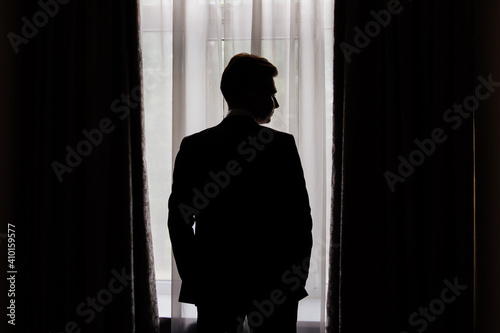 silhouette. man in jacket near the window. businessman. fiance.