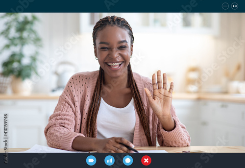 Joyful black woman making video call with laptop in kitchen interior, screenshot photo
