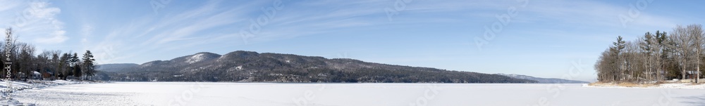 Panoramic view of a winter scene of a lake and mountains in winter 