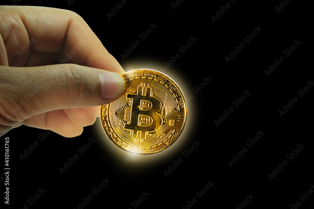 Hand holding Gold bitcoin on black background Hand holding Gold bitcoin on black background