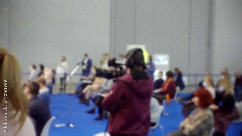 operator with a camera on a tripod works at a business presentation operator with a camera on a tripod works at a business presentation